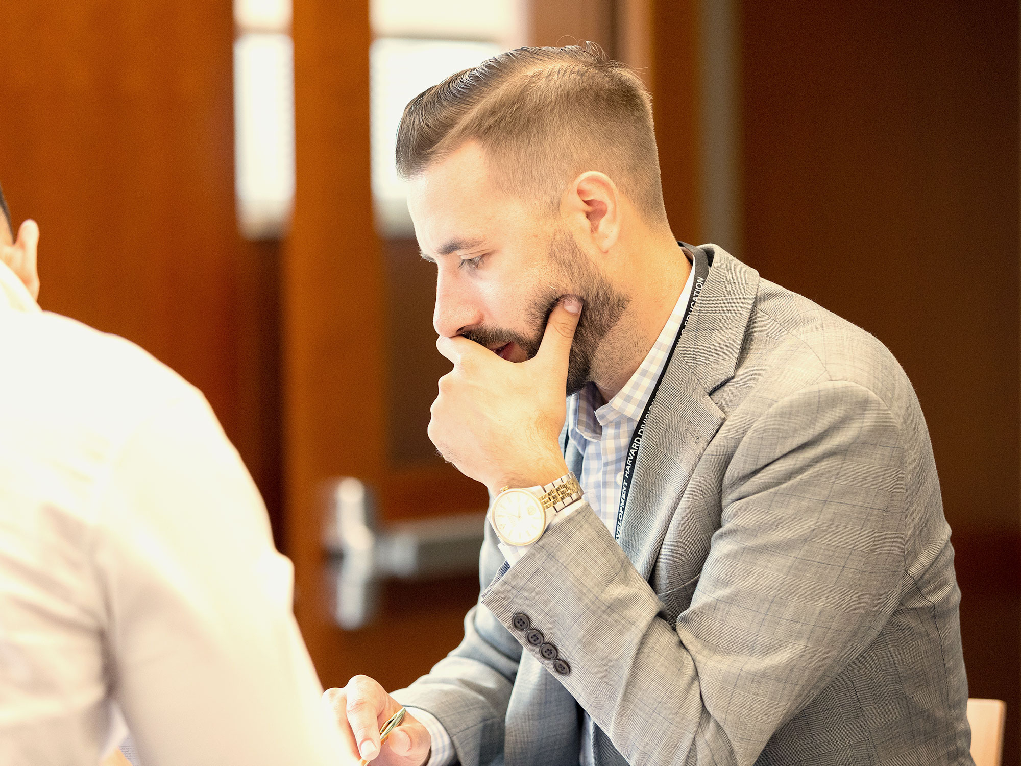 Man in suit thinking during a group discussion.