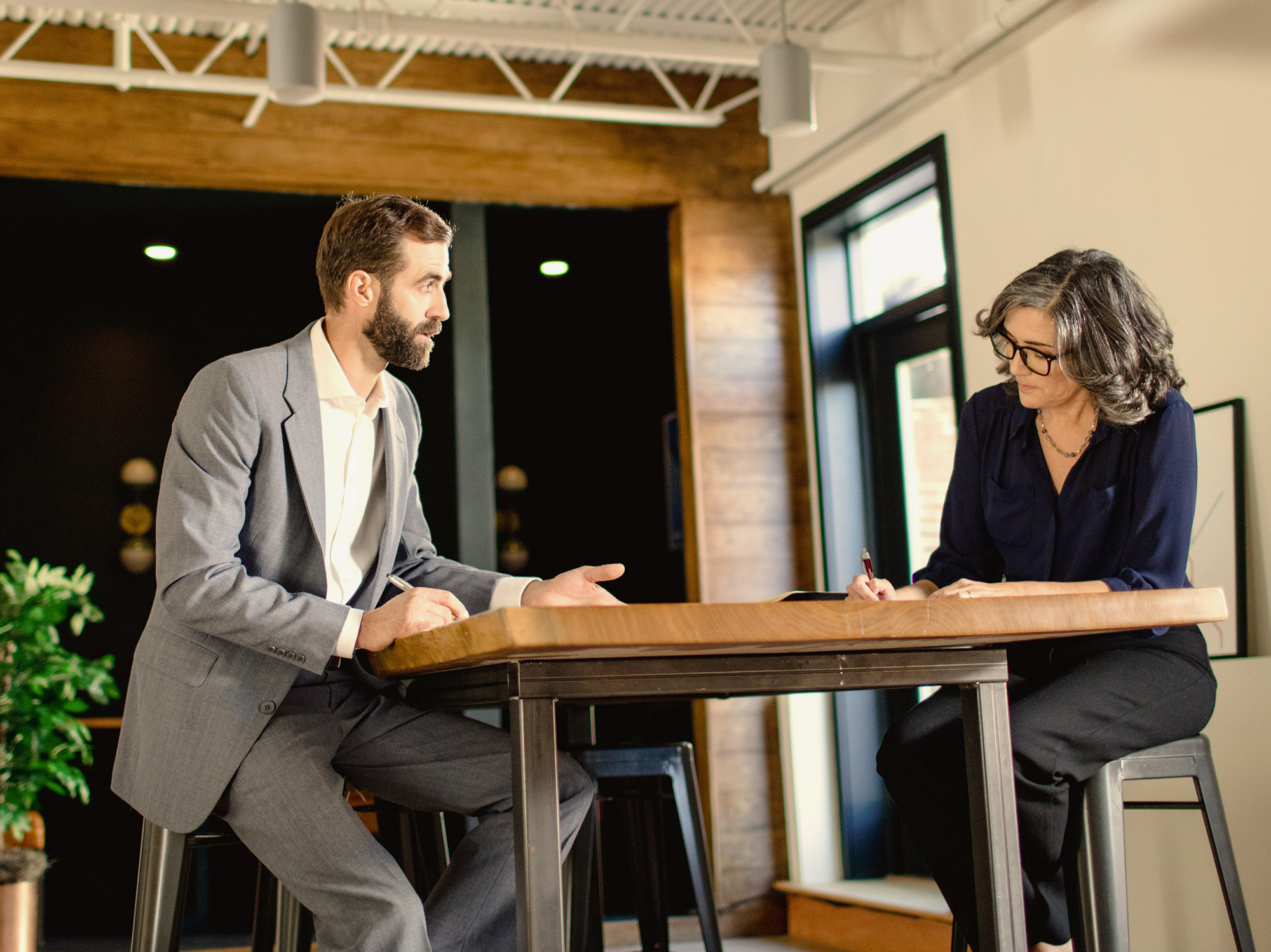 two professionals in discussion at table