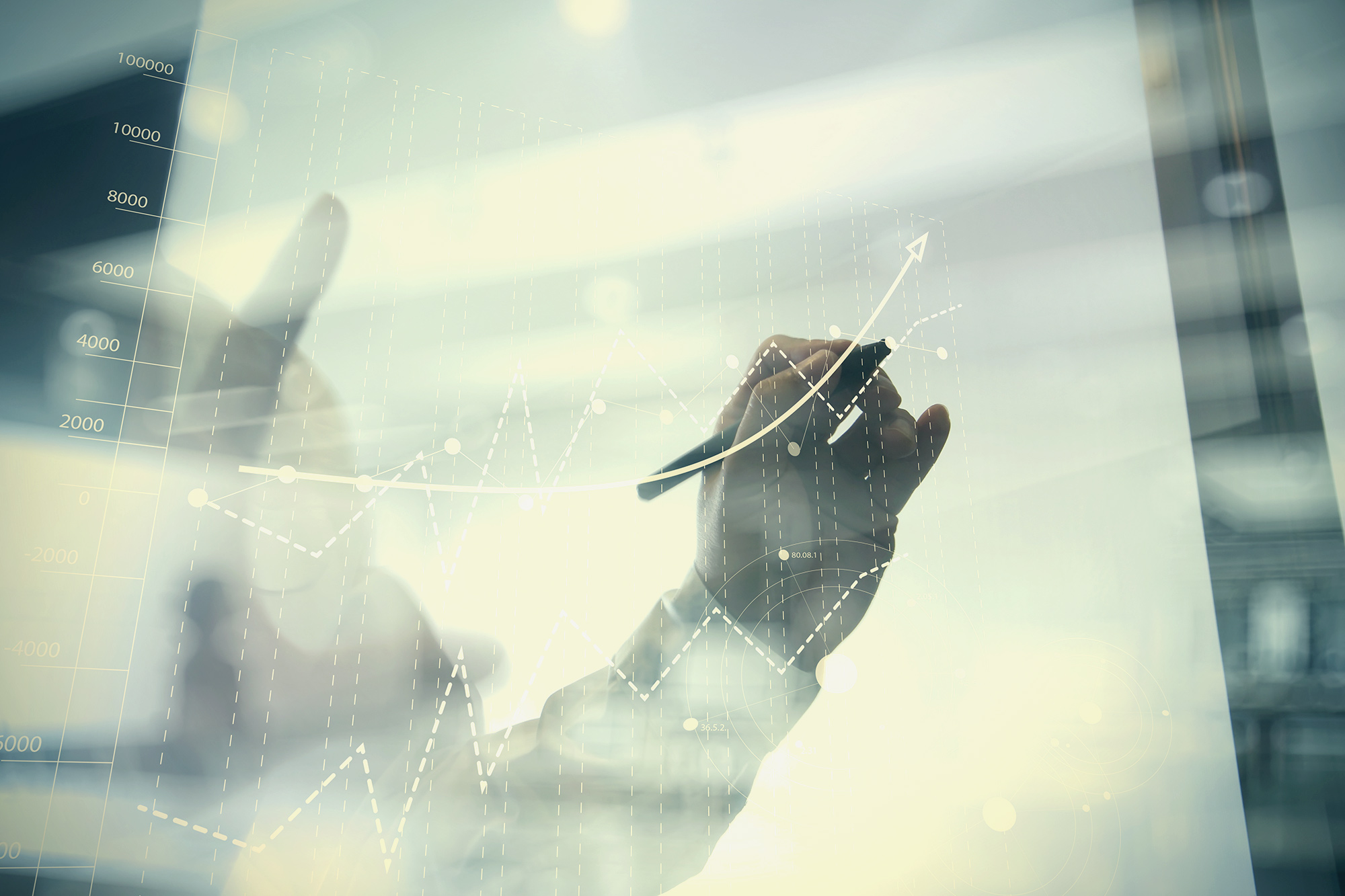 person writing financial concepts on glass board