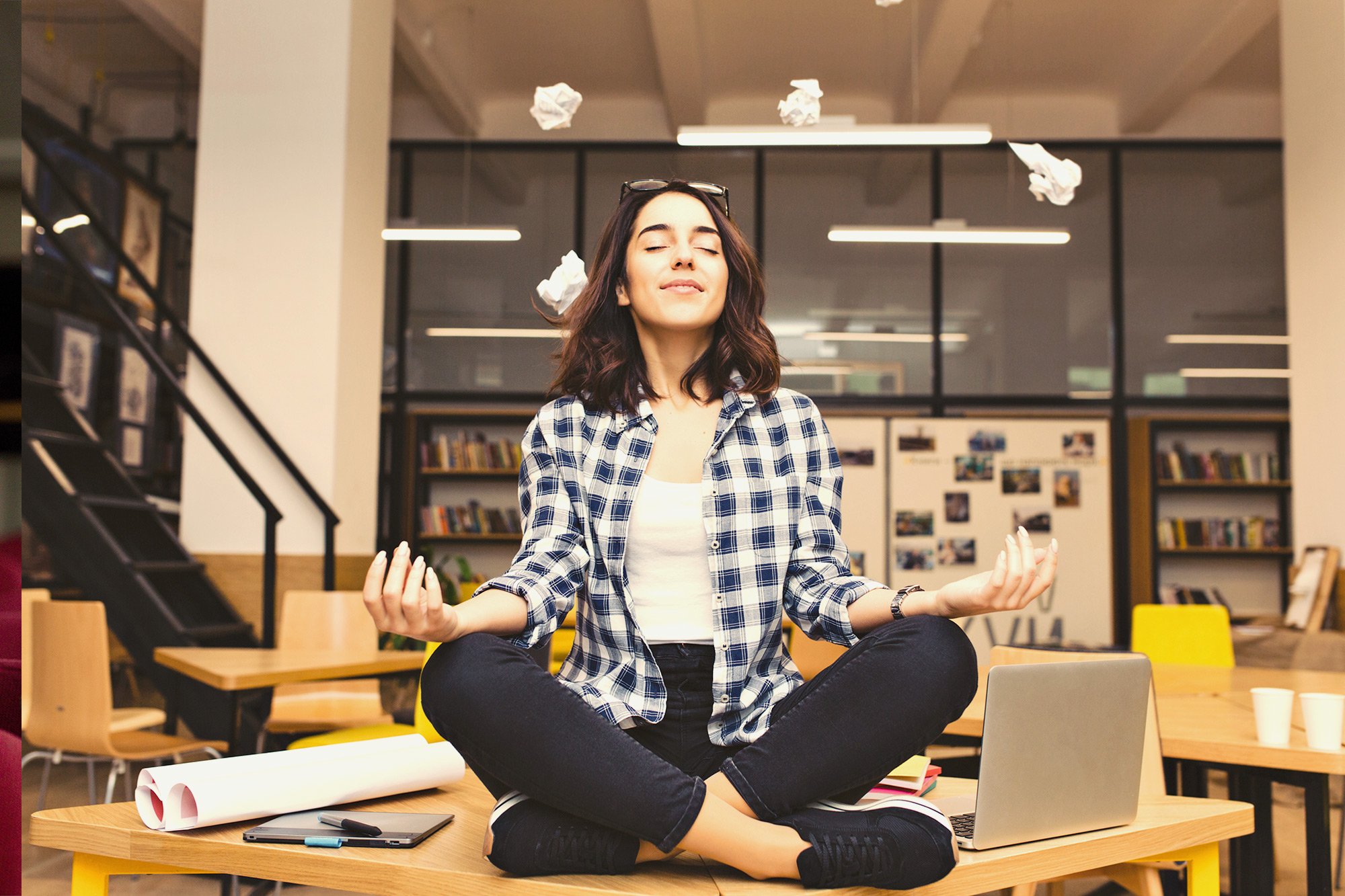 woman in sitting meditation pose on desk