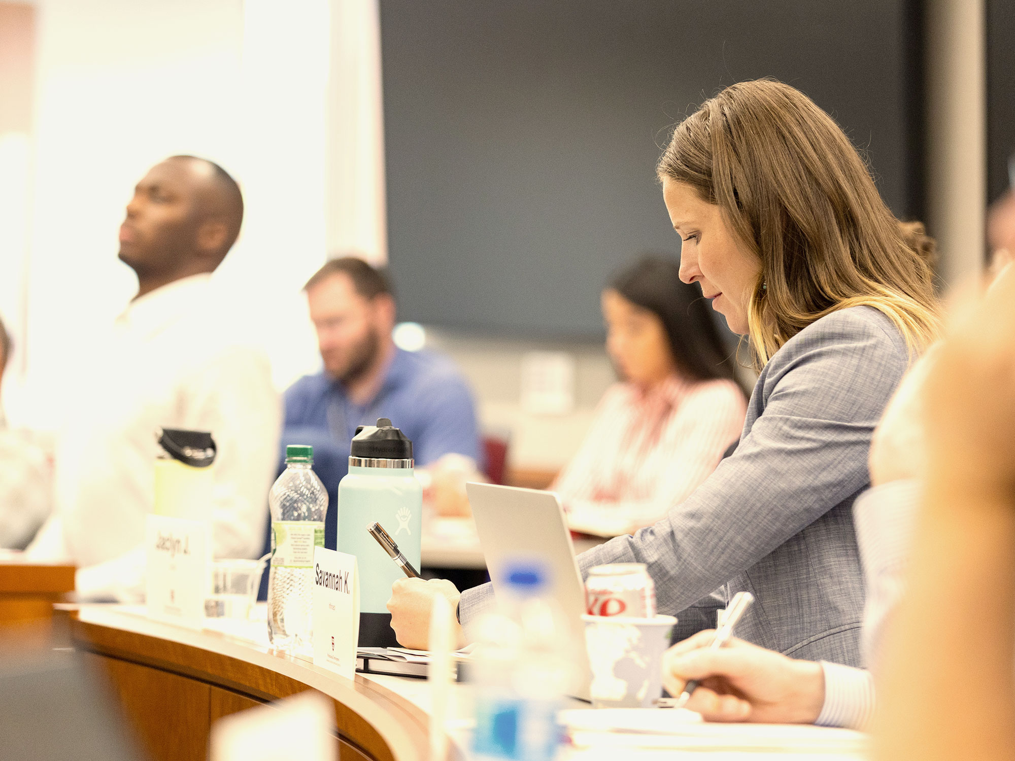 Woman typing and taking notes during a professional training session.