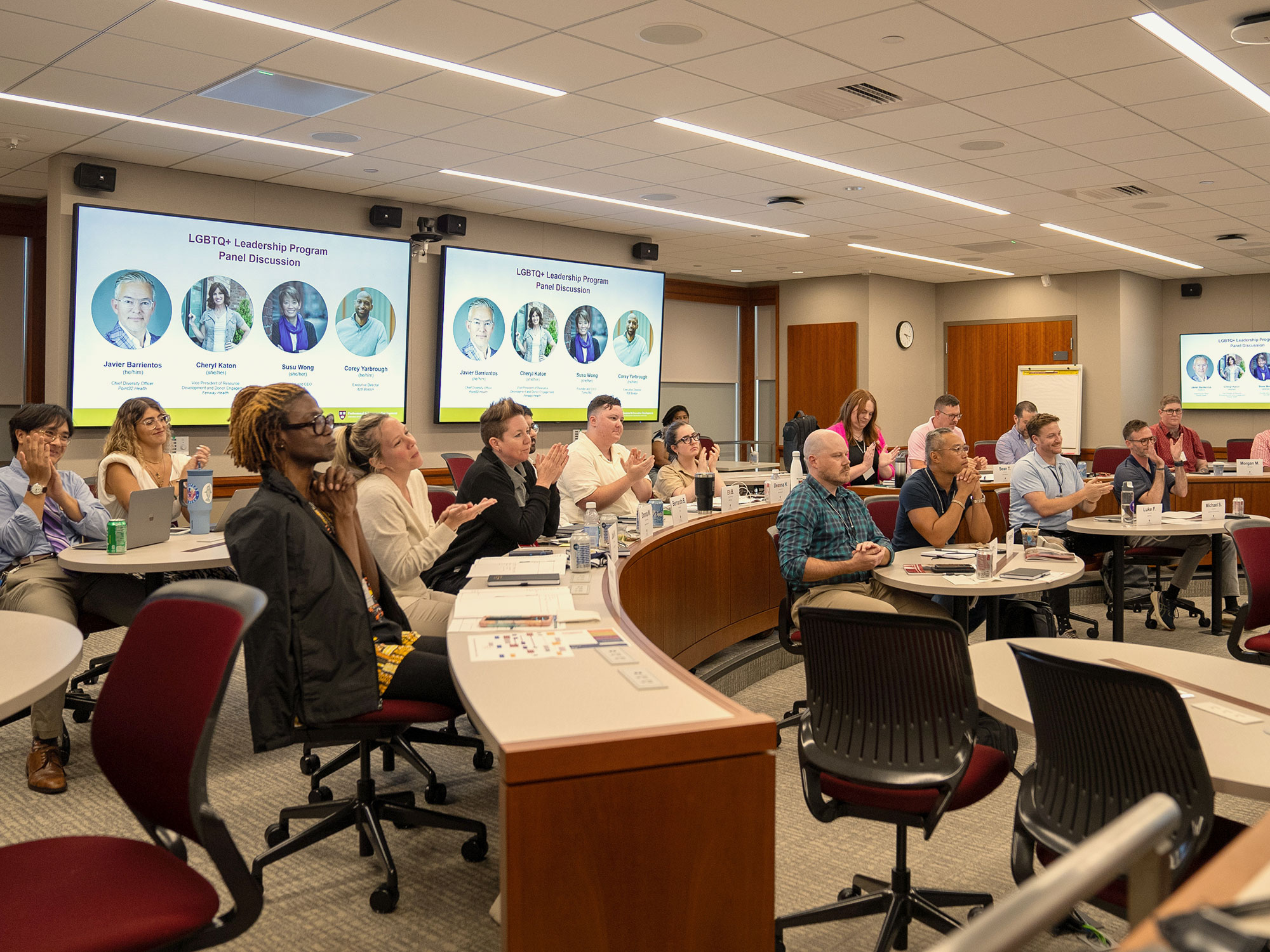 A diverse classroom full of adult learners all focused on a speaker out of frame