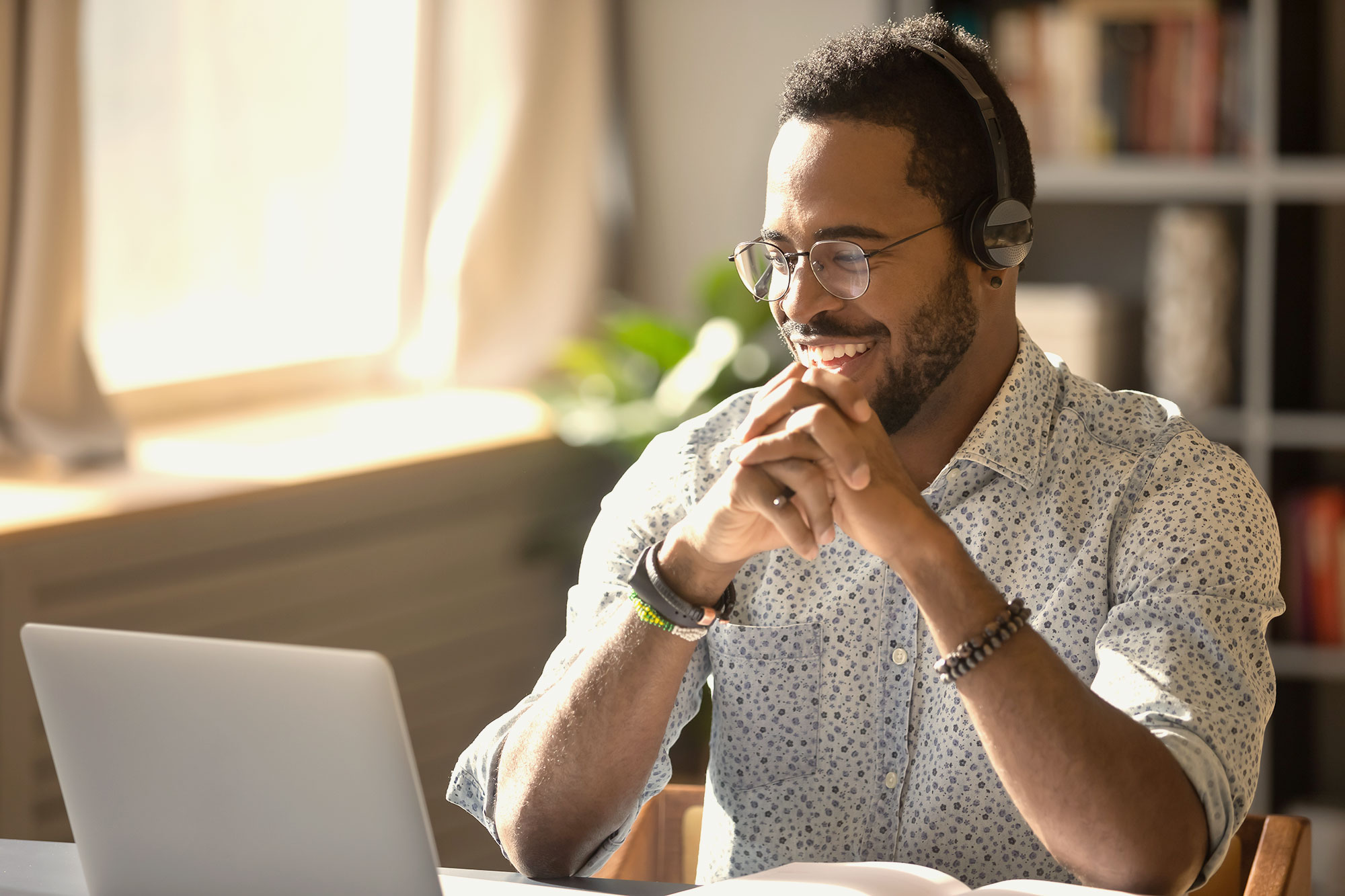 Person smiling at laptop screen.