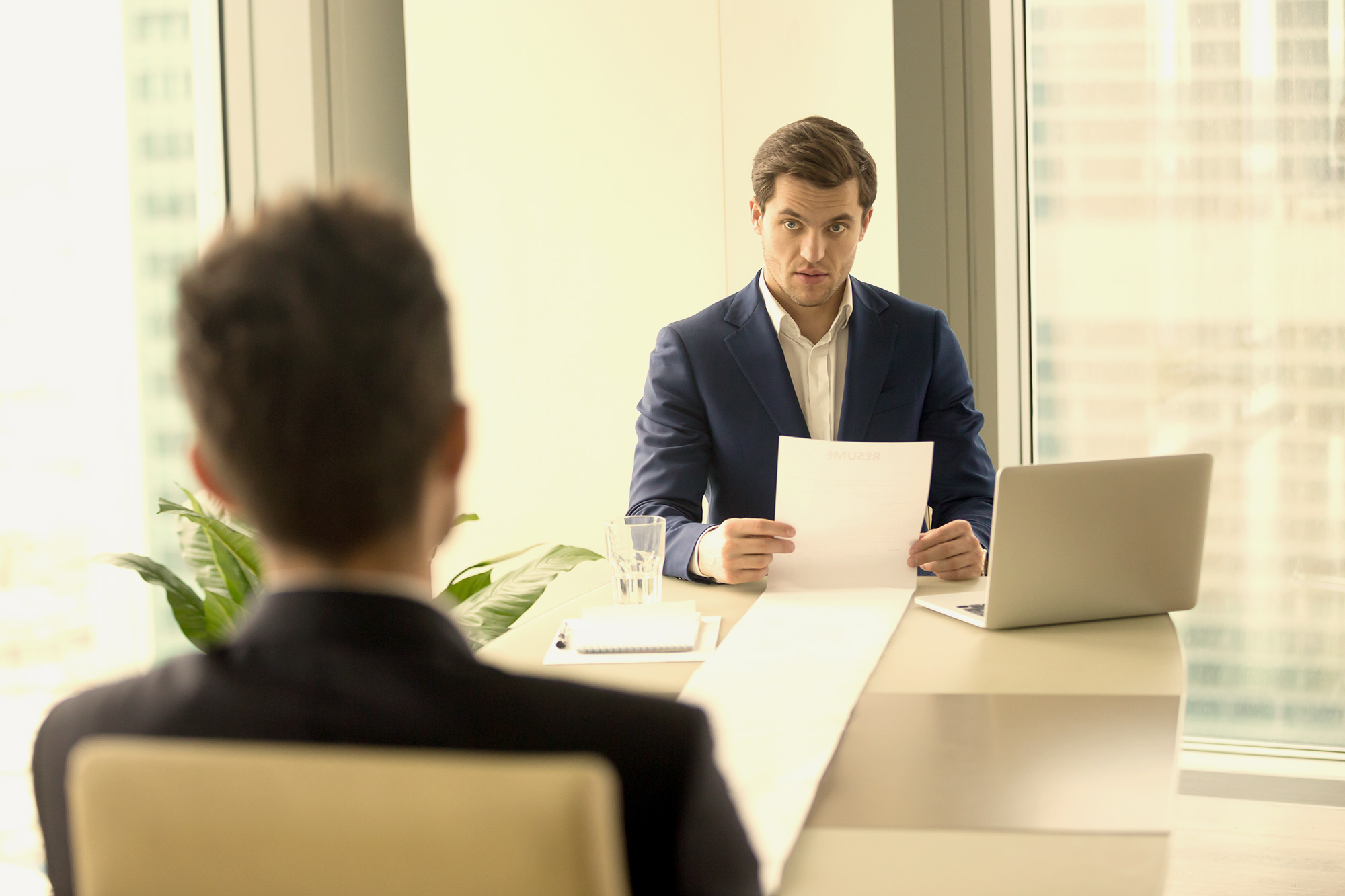 man at conference table presenting position